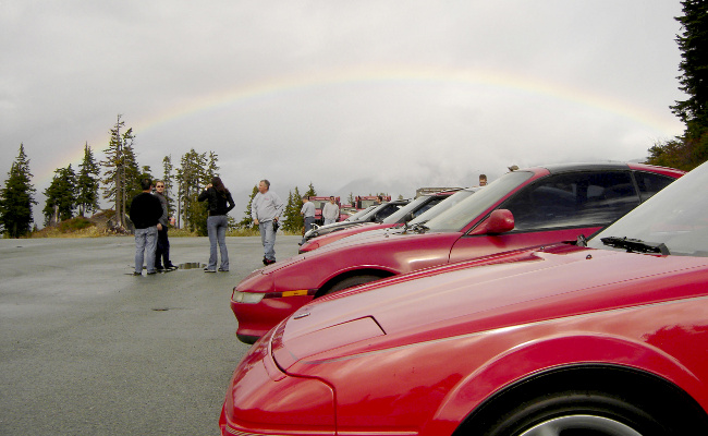 cars in foreground with rainbow in background